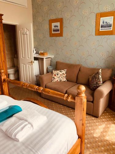 a living room with a couch and a bed at The Purple Tree Guest House in Torquay