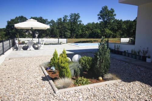 un patio trasero con piscina y sombrilla en Apartment - CASA Adrianovo, en Ljubuški