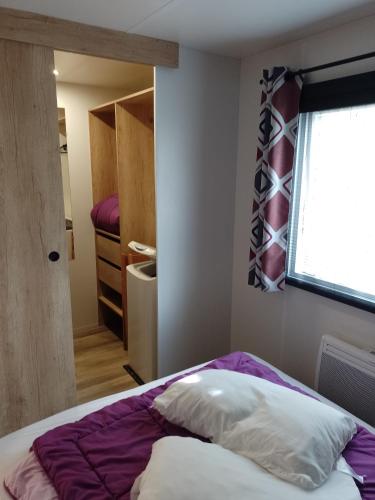 a bedroom with a bed with a window at MHVACANCES LOUENT PLUSIEURS MOBILHOMES DANS CAMPING 4 ETOILES PROCHE CHATEAUX et ZOO BEAUVAL in Onzain