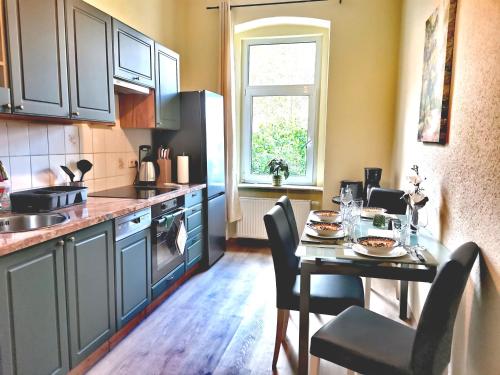 a kitchen with a table and a dining room at VogelWarte - gemütlich, gut ausgestattet, zentrumsnah in Plauen