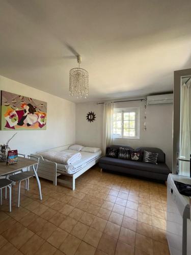 un salon avec un lit et un canapé dans l'établissement Appartement en Rez de Villa Beausite, à Mandelieu-la-Napoule