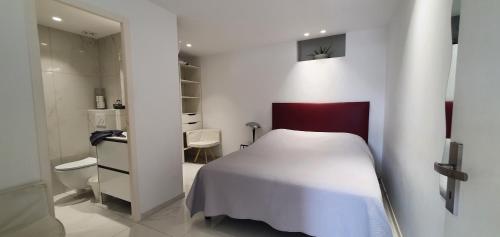 a bedroom with a white bed and a bathroom at Villa HARMONY in Vallauris