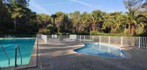 une piscine entourée d'une clôture blanche. dans l'établissement Villa HARMONY, à Vallauris