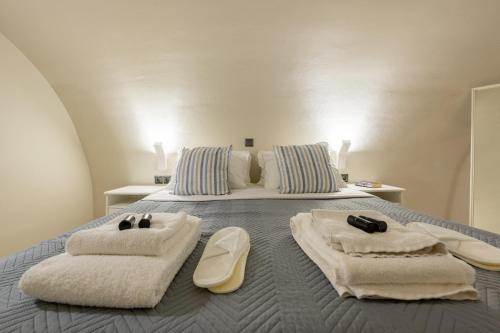 Un dormitorio con una cama con toallas. en Adagio Villas Kamari, en Kamari