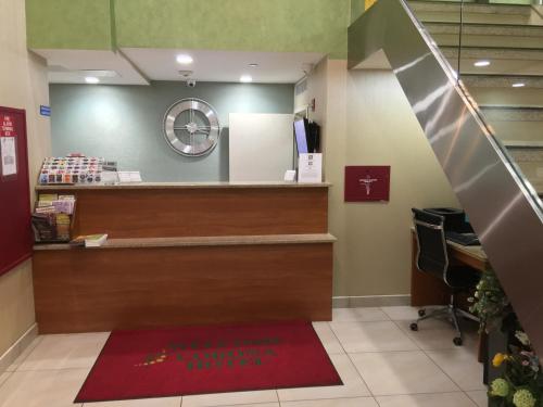 a lobby of a hospital with a checkout counter at Corona Hotel New York - LaGuardia Airport in Queens