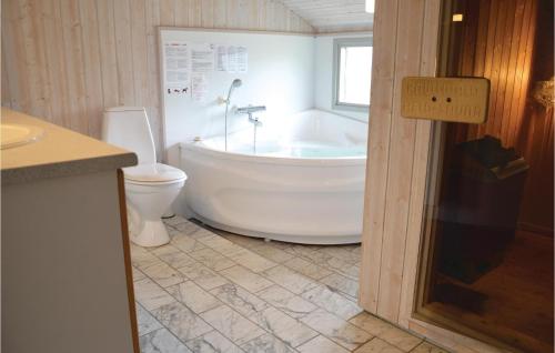 a bathroom with a white tub and a toilet at Holiday Home Klægdalen in Halkær