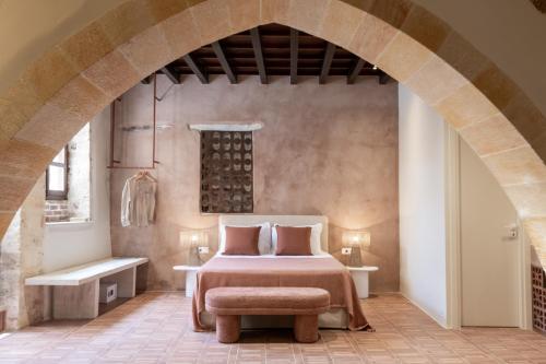 a bedroom with a bed and a chair in a room at Qualia Slowlife Suites in Chania Town
