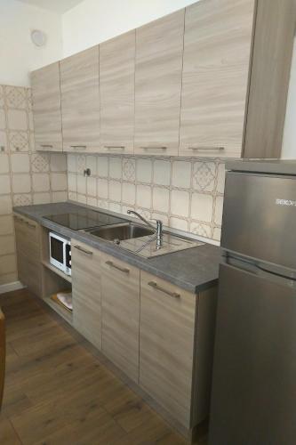 a kitchen with a sink and a stove at Residence Aurora Wellness & Spa in Albenga