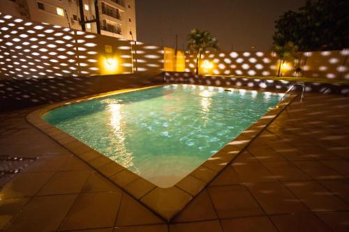 a swimming pool at night with lights at Accra Luxury Apartments at Clifton Place in East Legon