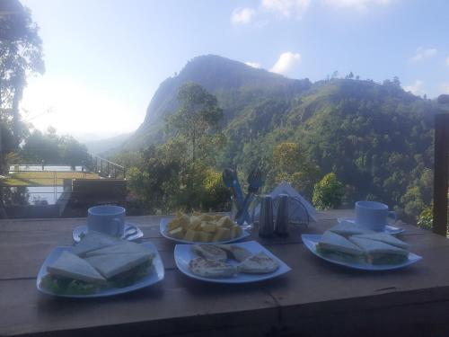 a table with two plates of food with a mountain in the background at Ella floating view in Ella