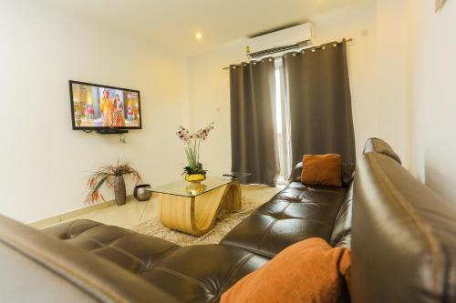 a living room with a leather couch and a coffee table at Accra Luxury Apartments at Clifton Place in East Legon