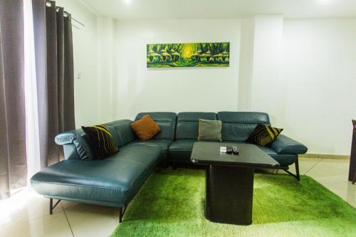 a living room with a blue couch and a table at Accra Luxury Apartments at Clifton Place in East Legon