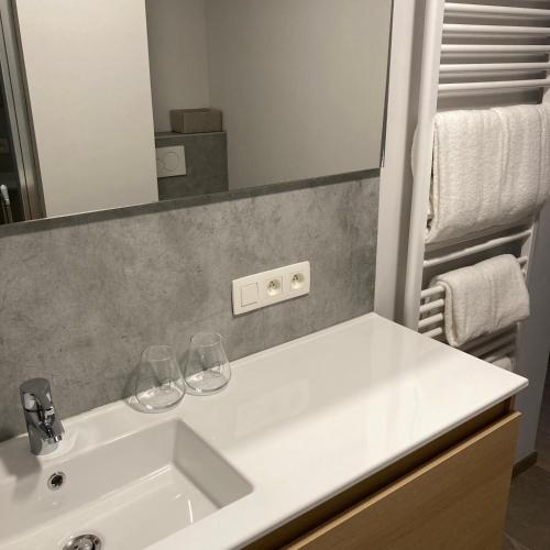 a bathroom with a sink with two wine glasses on it at DeStoker in Hasselt