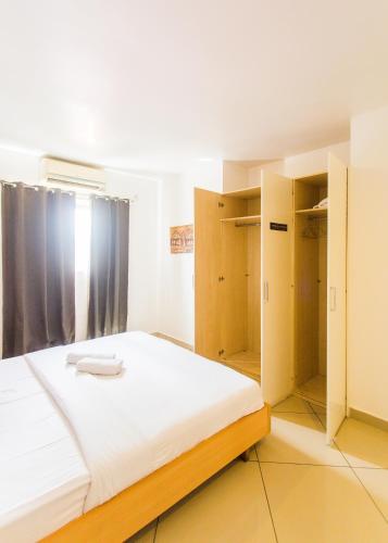 a bedroom with a large bed with wooden cabinets at Accra Luxury Apartments at Clifton Place in East Legon