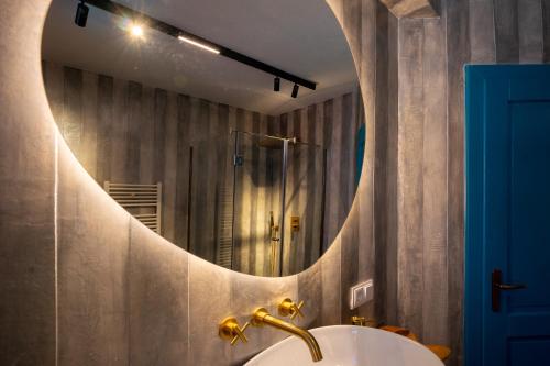 ein Badezimmer mit Waschbecken und Spiegel in der Unterkunft Blue House Citadel Elite Sighisoara in Sighişoara