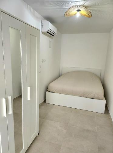 - une petite chambre avec un lit et un placard dans l'établissement Le Cassidain - Port et plage - Luxious appartement, à Cassis