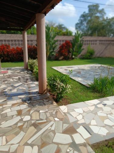 a stone patio with a gazebo in a yard at Elite Serviços Lda in Chibungo