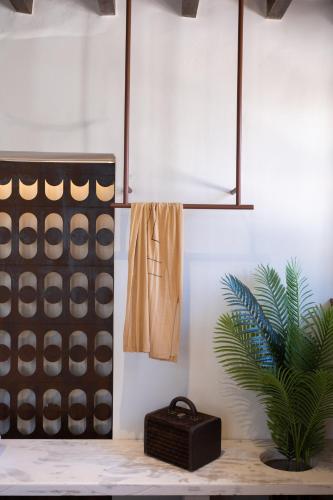 a room with a potted plant and a towel at Qualia Slowlife Suites in Chania Town