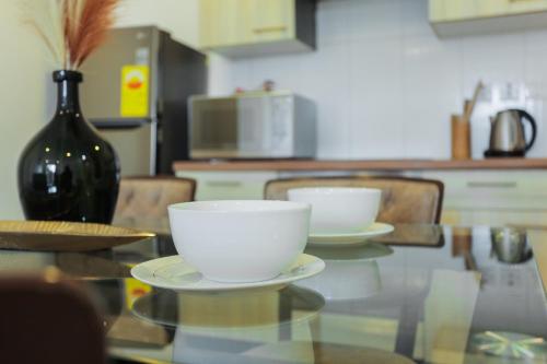 a table with two white bowls on top of it at Accra Luxury Apartments at Clifton Place in East Legon