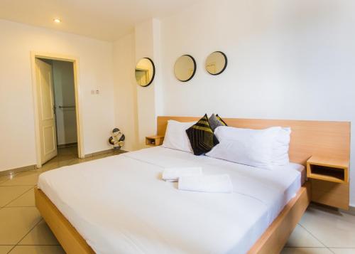 a large white bed in a room with two mirrors at Accra Luxury Apartments at Clifton Place in East Legon