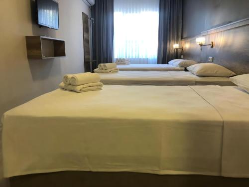 a row of four beds in a hotel room at Rinascente in Edirne