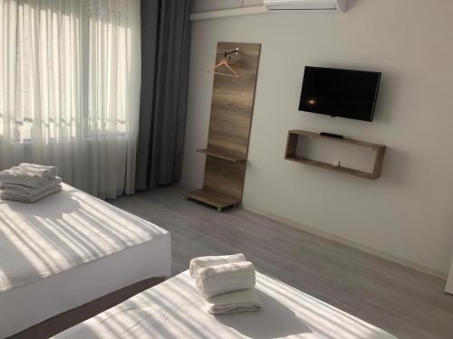 a room with two beds and a flat screen tv at Rinascente in Edirne