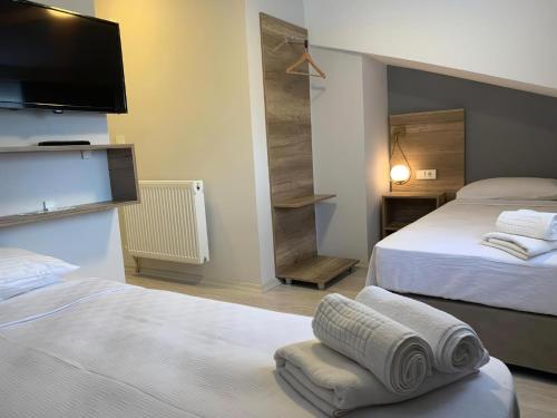 a hotel room with two beds and a flat screen tv at Rinascente in Edirne