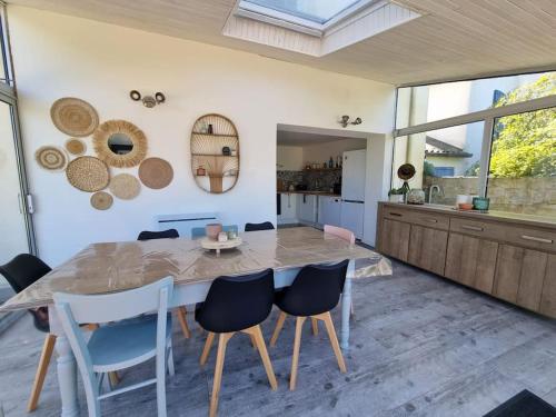 une cuisine et une salle à manger avec une table et des chaises dans l'établissement Maison Les 3 Soeurs - 8 à 10 personnes - plages à pied, à Brignogan-Plage