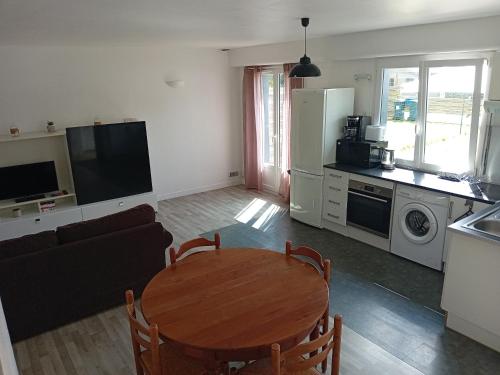 Il comprend un salon avec une table en bois et une cuisine. dans l'établissement Chez Jean Jacques, à Ploemeur