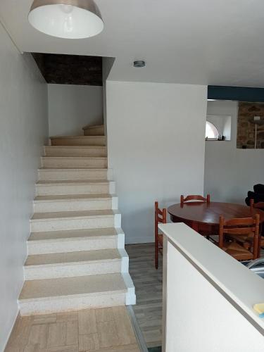 Un escalier mène à une chambre avec une table. dans l'établissement Chez Jean Jacques, à Ploemeur