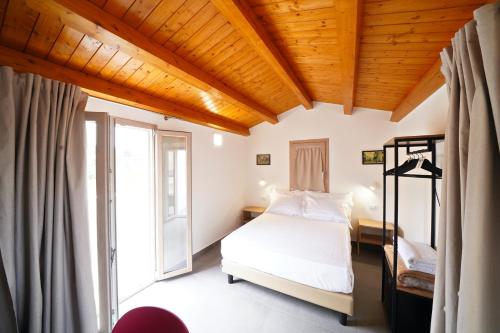 a bedroom with a bed and a large window at Ducas Rooms and Suite in Lascari