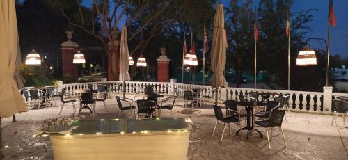 an outdoor patio with tables and chairs and umbrellas at Gran Hotel Aqualange - Balneario de Alange in Alange
