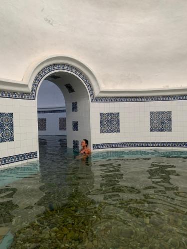 a woman in the water in a swimming pool at Gran Hotel Aqualange - Balneario de Alange in Alange