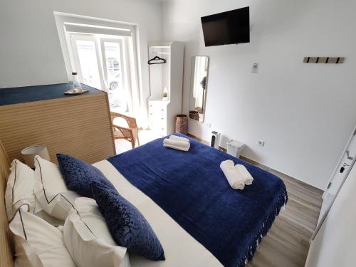 a bedroom with a bed and a blue blanket at Costa Paradise Beach in Costa da Caparica