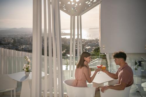 a man and a woman sitting at a table with drinks at Lagon Life Spirit Boutique Hotel - Adults Only in Chania Town