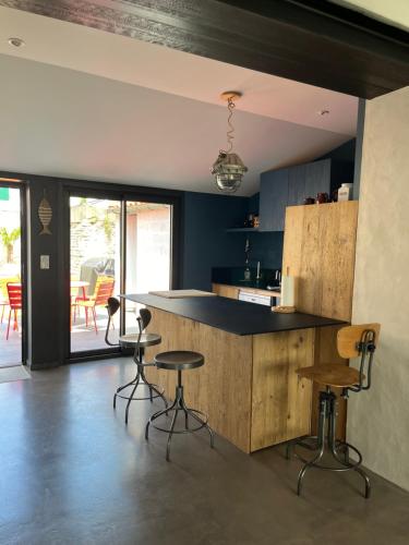 - une cuisine avec un comptoir et des tabourets dans l'établissement Elégante maison familiale au cœur des remparts de la citadelle, au Château-dʼOléron