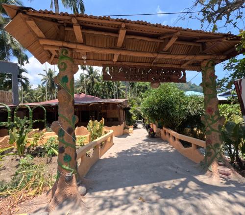 a wooden pergola in a garden with a walkway at Havelock Farms Resort in Havelock Island