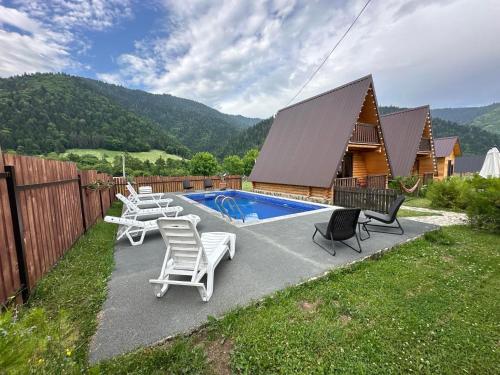 a backyard with a pool with chairs and a house at Eco House Borjomi in Borjomi