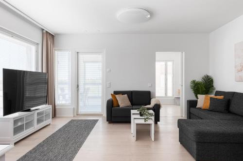 a living room with a couch and a tv at Borg Katarina - Riverside View in Pori