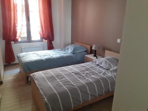 une chambre avec deux lits et une fenêtre dans l'établissement Appartement 80m2, à Castellane