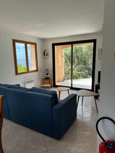 a living room with a blue couch and a table at Villa acula in Olmeto