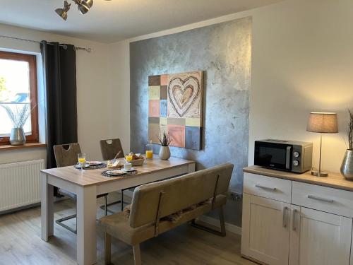comedor con mesa con sillas y microondas en Ferienwohnung Augenblicke, en Olsberg