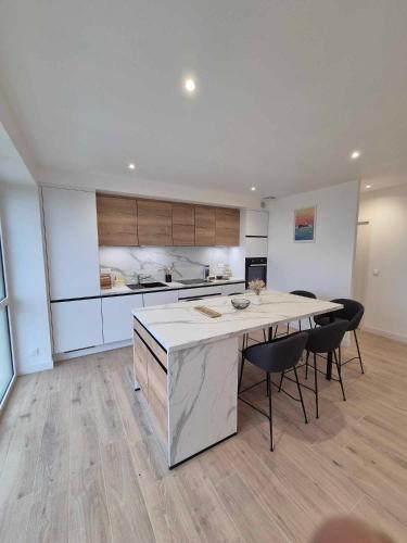 une cuisine avec une table et des chaises dans une pièce dans l'établissement TREVIGNON - Ty Bihan Anna, à Trégunc