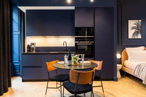 a kitchen and dining room with purple walls and a table and chairs at MOHOM - Bellecordière in Lyon