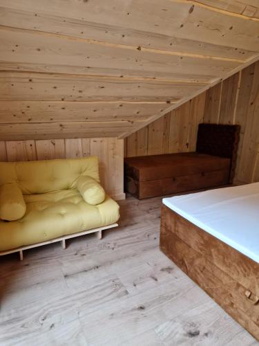 a bedroom with a bed and a couch in a room at Chata Braci Warchały in Warchały
