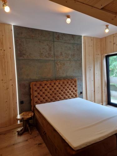 a bedroom with a bed and a bench and a window at Chata Braci Warchały in Warchały