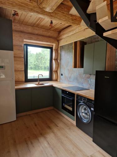 a kitchen in a log cabin with a sink and a window at Chata Braci Warchały in Warchały