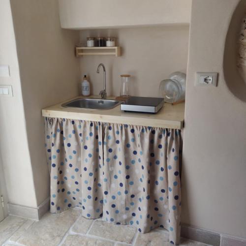 a kitchen counter with a sink in a room at Trullo del Sol in Ceglie Messapica