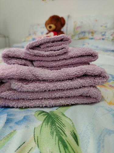 a purple blanket on a bed with a teddy bear at Casa dell'orso in Rocca di Botte