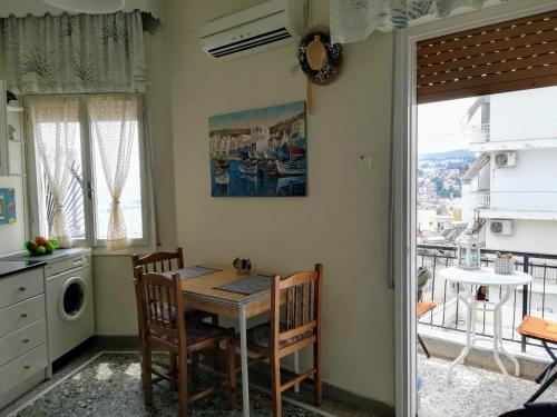 a kitchen with a table and chairs and a window at Lydia Home in Kavala